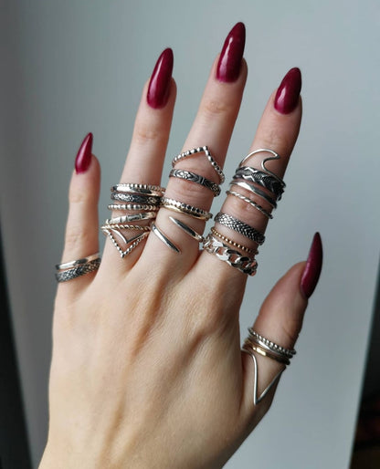 A hand wearing lots of silver rings.